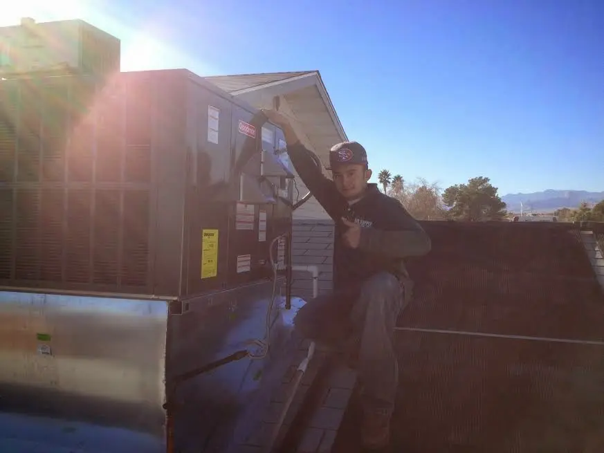 HVAC technician performing Air Duct Cleaning on a rooftop unit in Big Bear Lake
